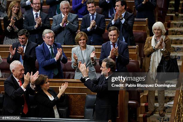 Acting Spanish Prime Minister Mariano Rajoy applauses his party members after winning the investiture debate at the Spanish Parliament on October 29,...