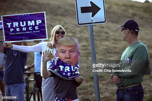 Supporters stand on the side of the road as Republican presidential nominee Donald Trump's motorcade leaves a campaign rally in the Rodeo Arena at...