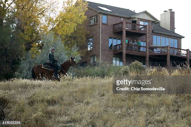 Horse mounted sheriff's deputy watches as Republican presidential nominee Donald Trump's motorcade leaves a campaign rally in the Rodeo Arena at the...