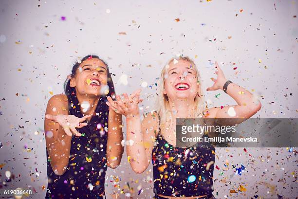 best friends smiling under confetti rain - makeup in rain photos et images de collection