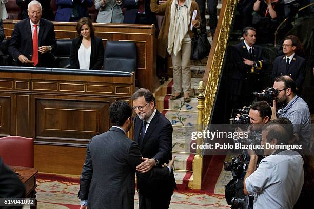 Leader of the Socialist party Antonio Hernando congratulates acting Spanish Prime Minister Mariano Rajoy after Rajoy won the investiture debate at...