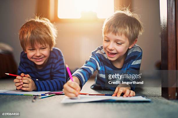 little brothers enjoying drawing on the floor - colouring stock pictures, royalty-free photos & images