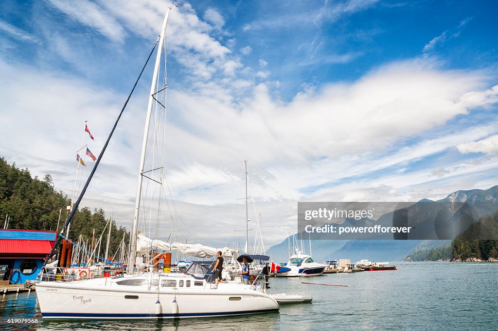 People aboard sailboat in marina at Horseshoe Bay, Canada