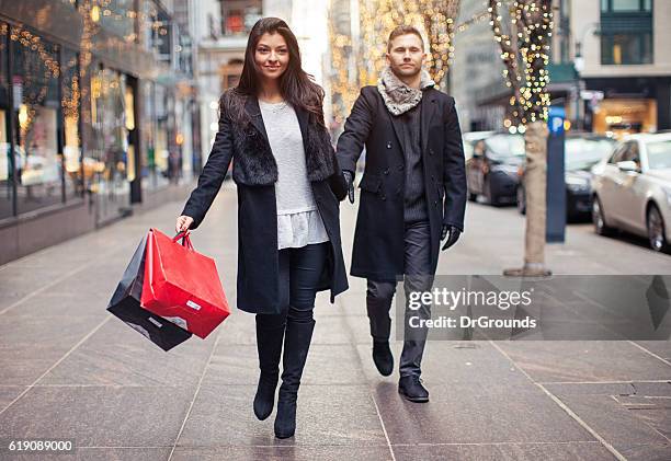 excited woman going shopping with sad husband - shopping disappointment stock pictures, royalty-free photos & images