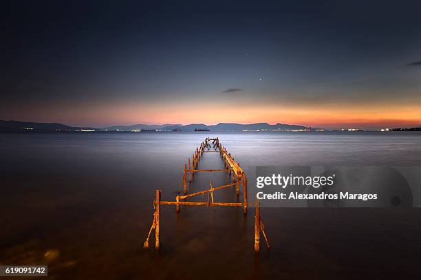 old broken pier at dramatic sunset - alexandros maragos stock pictures, royalty-free photos & images