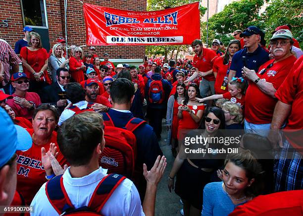 Mississippi Rebels players greet fans as they walk down Walk of Champions in the Grove before an NCAA college football game against the Auburn Tigers...