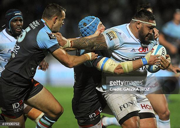 Racing's prop Ben Tameifuna is tackled by Bayonne's french flanker Jean Monribot and Bayonne's French fullback Romain Martial during the French Top...
