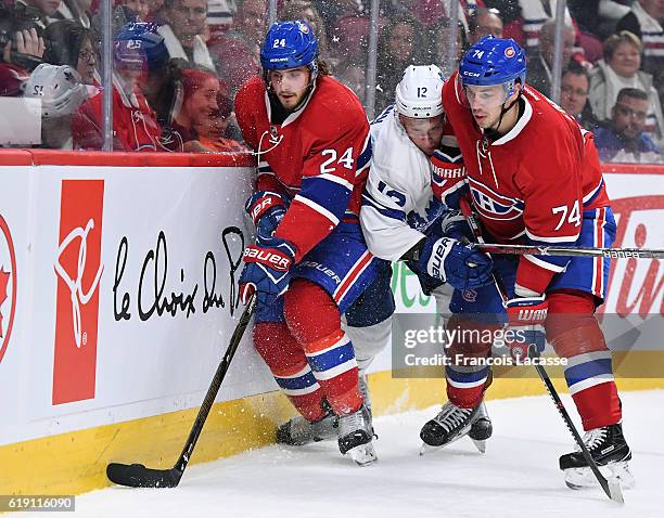 Alexei Emelin of the Montreal Canadiens checks into the boards Connor Brown the Toronto Maple Leafs in the NHL game at the Bell Centre on October 29,...