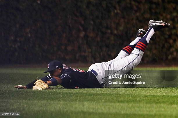 Rajai Davis of the Cleveland Indians dives and fails to make a catch in the first inning against the Chicago Cubs in Game Four of the 2016 World...