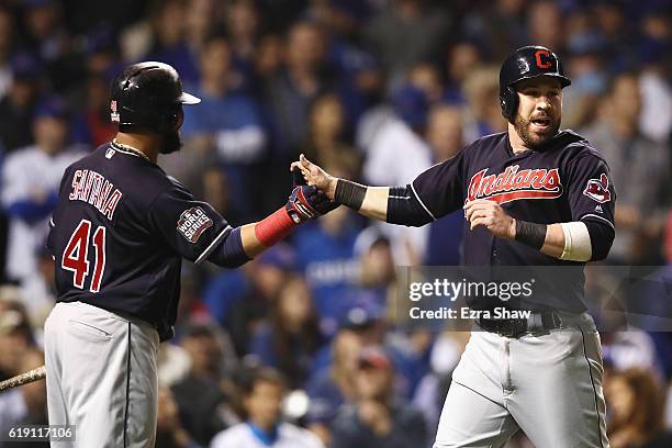 Carlos Santana of the Cleveland Indians congratulates Jason Kipnis after Kipnis scored a run in the third inning against the Chicago Cubs in Game...
