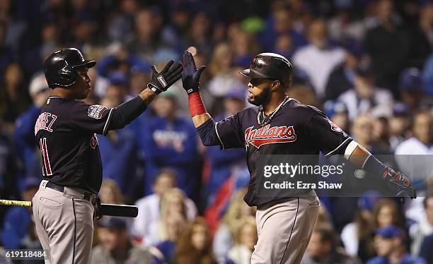 Jose Ramirez of the Cleveland Indians congratulates Carlos Santana after Santana hit a home run in the first inning against the Chicago Cubs in Game...