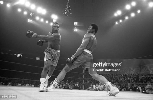 Muhammad Ali steps away from a roundhouse left thrown by Joe Frazier during their title bout here March 8th. Frazier became undisputed heavyweight...