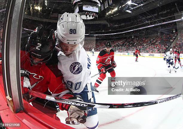 John Moore of the New Jersey Devils battles for the puck against Vladislav Namestnikov of the Tampa Bay Lightning during their game at the Prudential...