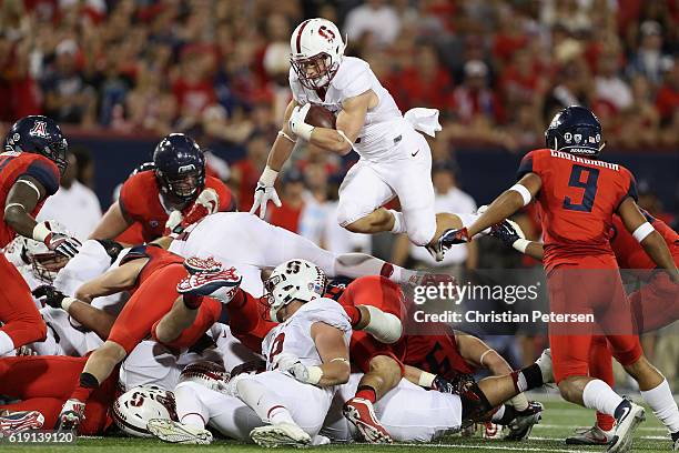 Running back Christian McCaffrey of the Stanford Cardinal leaps with the football as he rushes against the Arizona Wildcats during the second quarter...