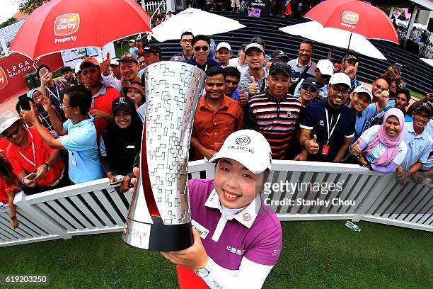 Shanshan Feng of China lifts the Sime Darby LPGA trophy aloft in front of cheering fans after she won it 17 under par 267 during day four of the Sime...