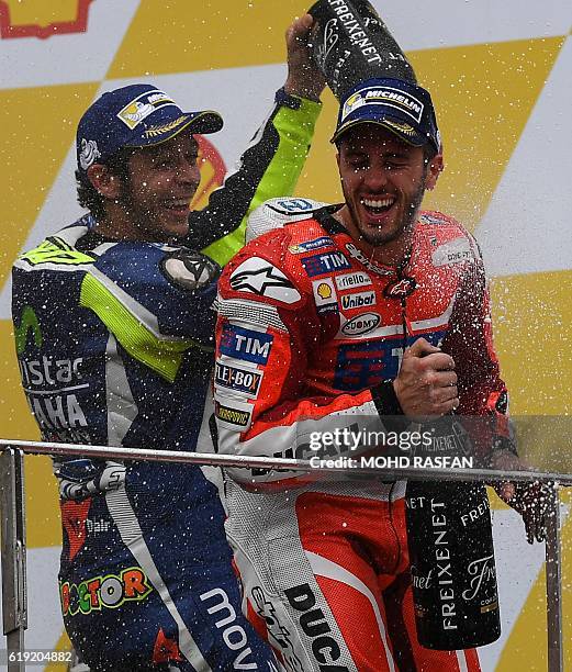 Second-placed Movistar Yamaha MotoGP's Italian rider Valentino Rossi pours champagne on Ducati Team's Italian rider and race winner Andrea Dovizioso...