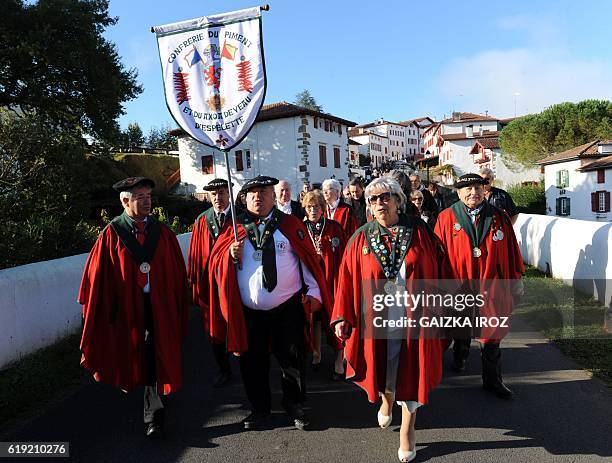 Members of the "brotherhood" of Espelette Pepper walk in a street of Espelette, southern France, on October 30, 2016 during the celebration of the...