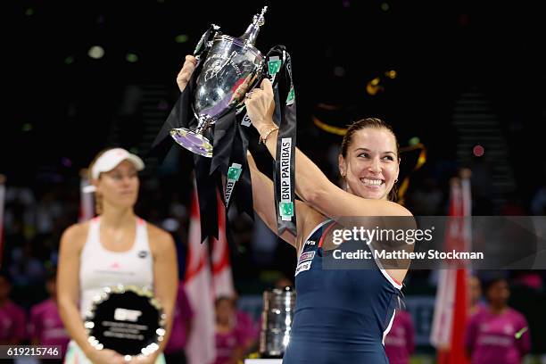 Dominika Cibulkova of Slovakia lifts the trophy after victory in her singles final against Angelique Kerber of Germany during day 8 of the BNP...