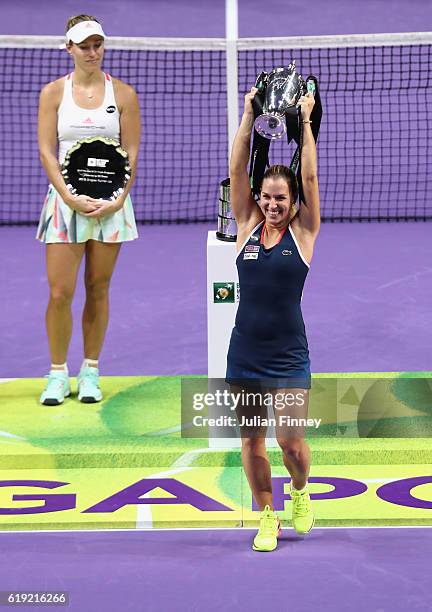 Dominika Cibulkova of Slovakia lifts the trophy after victory in her singles final against Angelique Kerber of Germany during day 8 of the BNP...
