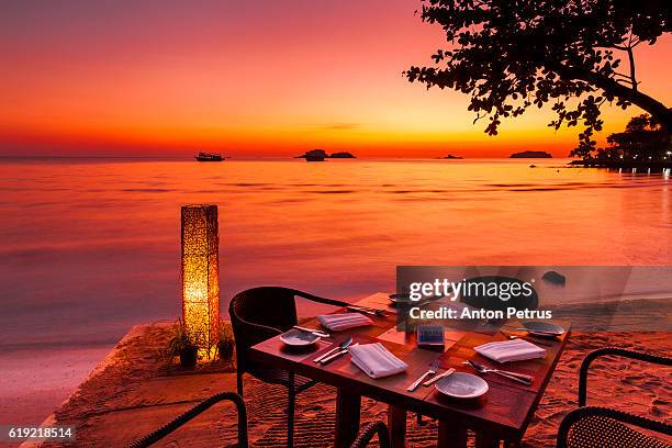 restaurant on the beach at sunset - bar de plage photos et images de collection