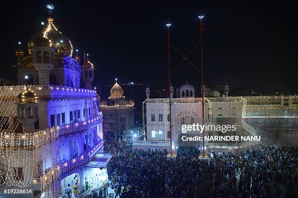 Indian Sikh devotees pay their respects and offer prayers during Bandi Chhor Divas, or Diwali, at the Golden Temple in Amritsar on October 30, 2016....