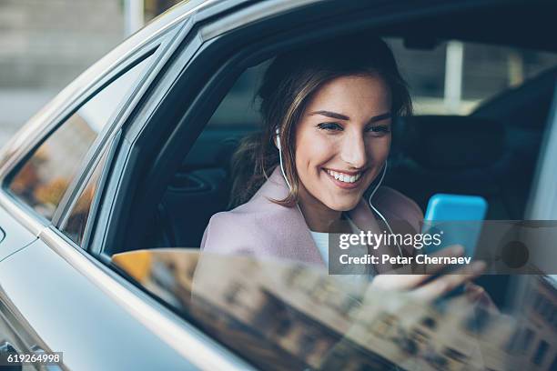 frau mit telefon auf dem rücksitz eines autos - cool boss stock-fotos und bilder