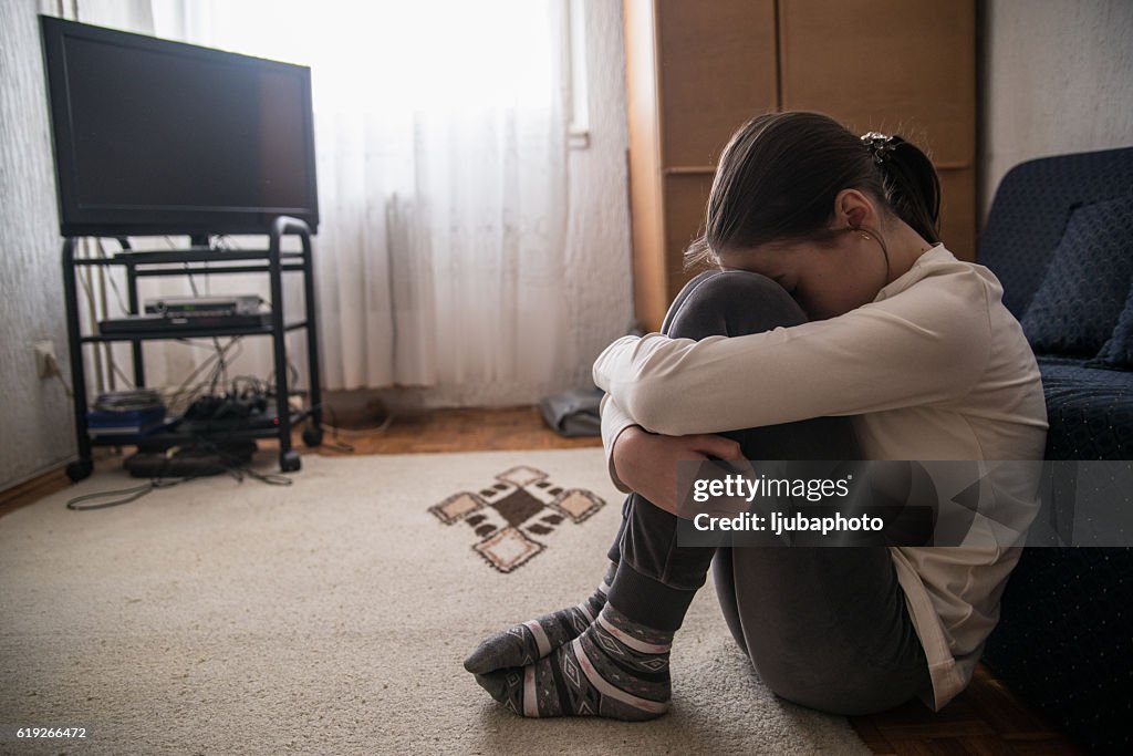 Teen woman with headache holding her head