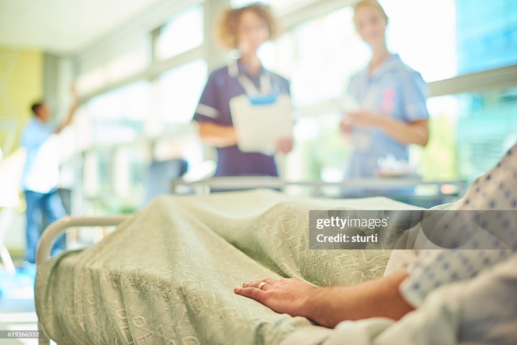 Senior nurse chatting to student nurse and patient