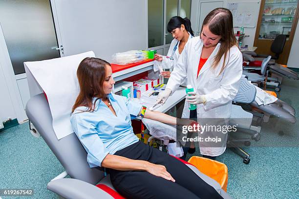 jeune femme à faire un don de sang dans le sang bank - prise de sang photos et images de collection