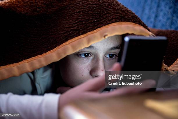 fille au lit textos sur smartphone - puberty girl photos et images de collection
