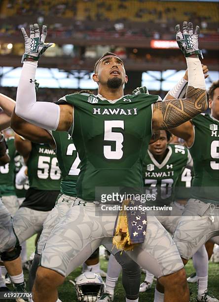 Hawai'I Rainbow Warriors defensive lineman Makani Kema-Kaleiwahea does the Haa while wearing a 50+ year old U.S. Flag given to him by a Vietnam...
