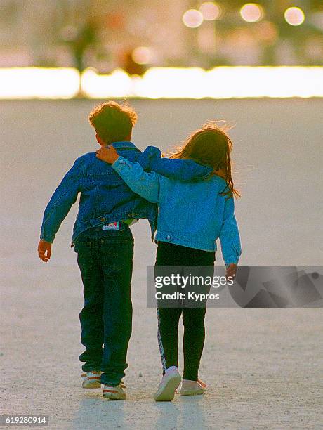 Europe, France, Paris, View Of Two Children Walking, Rear view, Hugging Each Other (1990s)