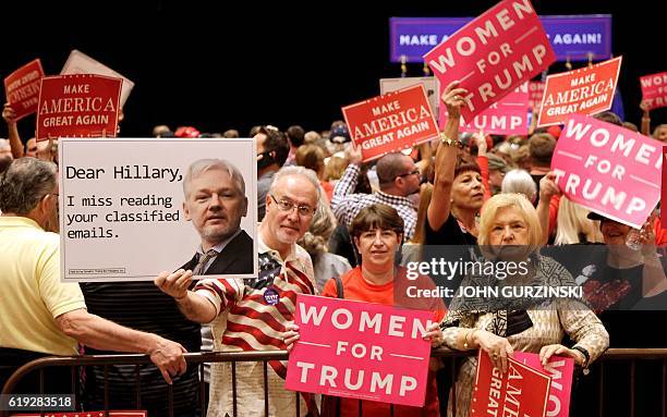 Supporters hold signs during a campaign rally for Republican presidential nominee Donald Trump at the Venetian Hotel on October 30, 2016 in Las...