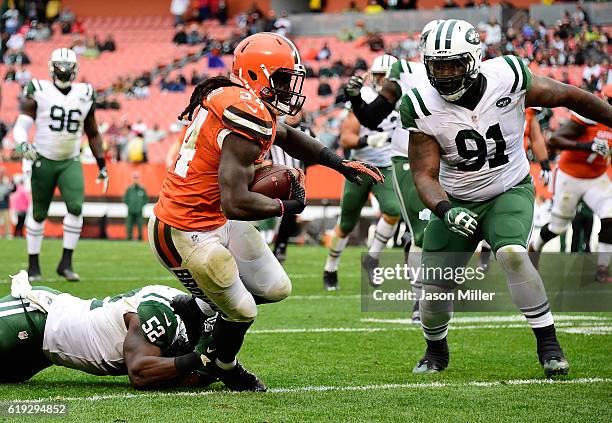 Isaiah Crowell of the Cleveland Browns carries the ball in front of the defense of David Harris and Sheldon Richardson of the New York Jets at...