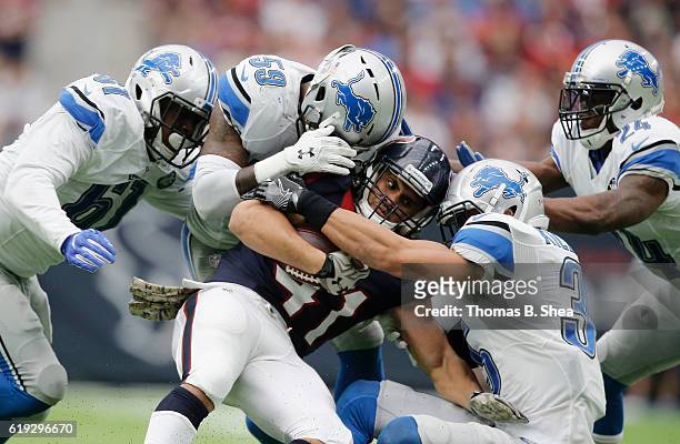 Jonathan Grimes of the Houston Texans is wrapped up by Tahir Whitehead of the Detroit Lions and Miles Killebrew in the fourth quarter at NRG Stadium...