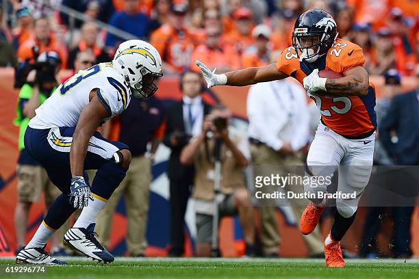 Running back Devontae Booker of the Denver Broncos reaches out to stiff arm inside linebacker Joshua Perry of the San Diego Chargers in the first...
