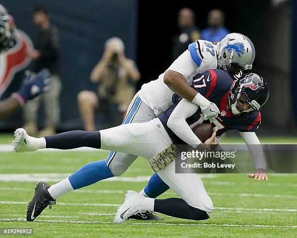 Brock Osweiler of the Houston Texans is sacked by Armonty Bryant of the Detroit Lions at NRG Stadium on October 30, 2016 in Houston, Texas.