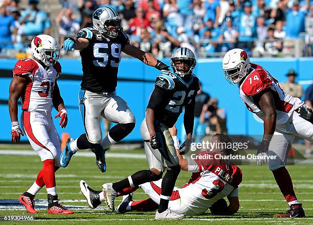 Carolina Panthers linebacker Luke Kuechly, left center, leaps through the air to congratulate cornerback Leonard Johnson, right center, following his...