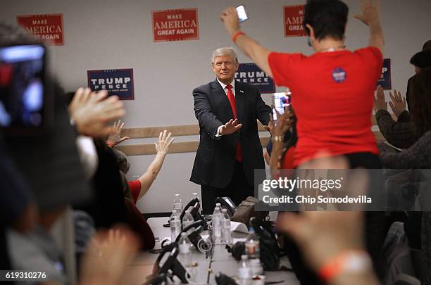 Republican presidential nominee Donald Trump reaches out and prays with volunteers at a campaign phone bank before a rally at the Bank of Colorado...