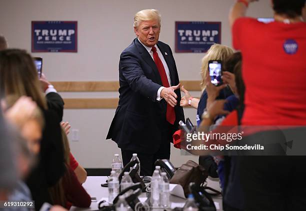 Republican presidential nominee Donald Trump greets volunteers at a campaign phone bank before a rally at the Bank of Colorado Arena on the campus of...