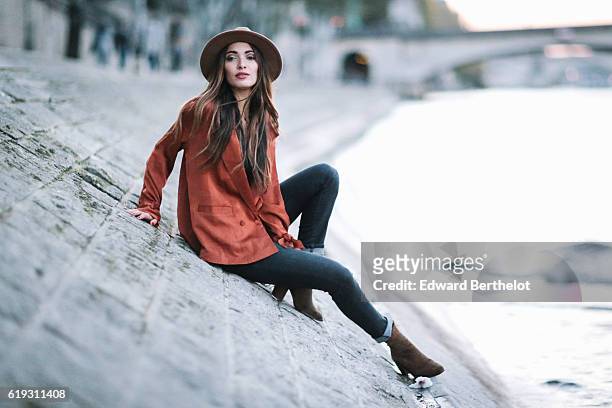 Sofya Benzakour , is wearing a hat, Reiko denim jeans, a Nakd Fashion orange shirt, Zara boots, and a Gucci brown bag, on October 30, 2016 in Paris,...