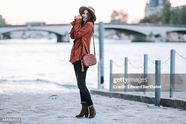 Sofya Benzakour , is wearing a hat, Reiko denim jeans, a Nakd Fashion orange shirt, Zara boots, and a Gucci brown bag, on October 30, 2016 in Paris,...