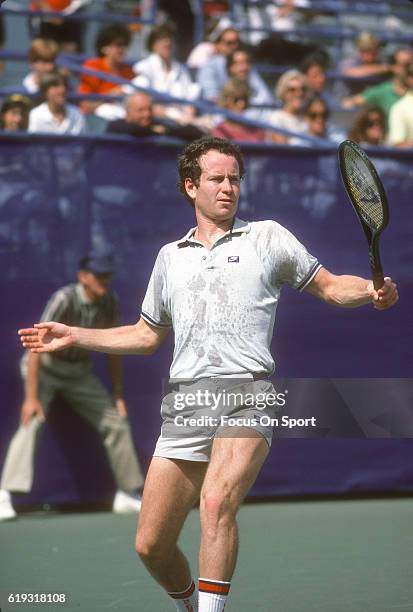 John McEnroe of the United States hits a return during a match in the Men's 1985 US Open Tennis Championships circa 1985 at the National Tennis...