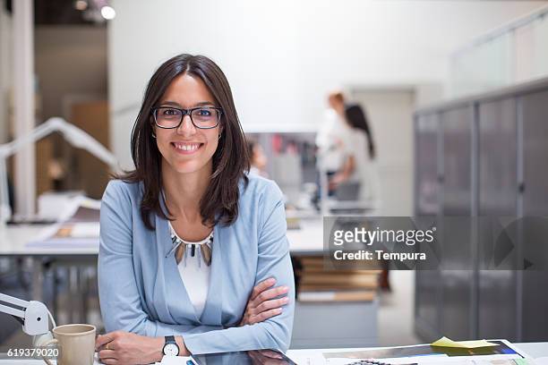 mujer de negocios sentada en su escritorio en la oficina corporativa. - profesional fotografías e imágenes de stock