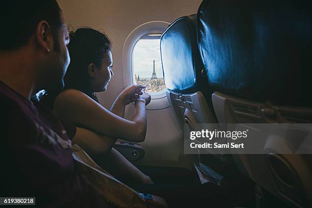 happy young couple enjoying paris from the airplane window - conveyor belt point of view stockfoto's en -beelden