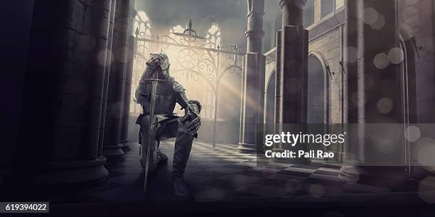 caballero medieval en armadura arrodillado con espada dentro del castillo - armoured fotografías e imágenes de stock