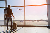 Serene young man watching plane before departure