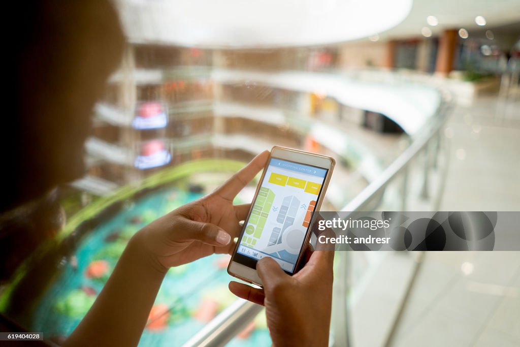 Shopping-Frau mit ihrem Handy in der Mall