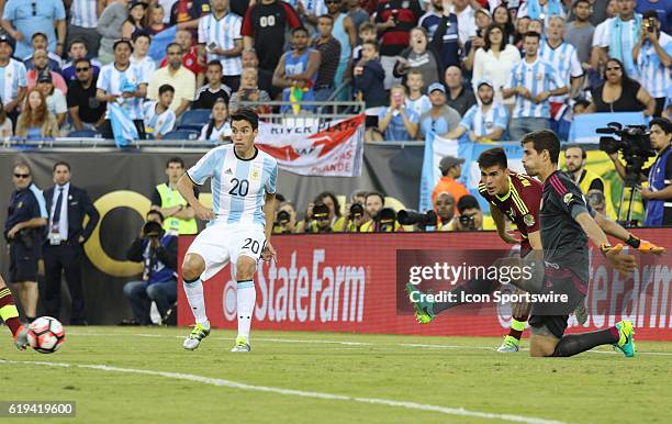 Venezuela goalkeeper Dani Hernandez eyes the ball as Argentina forward Nicolas Gaitan passes it in front. Argentina defeated Venezuela 4-1 in the...