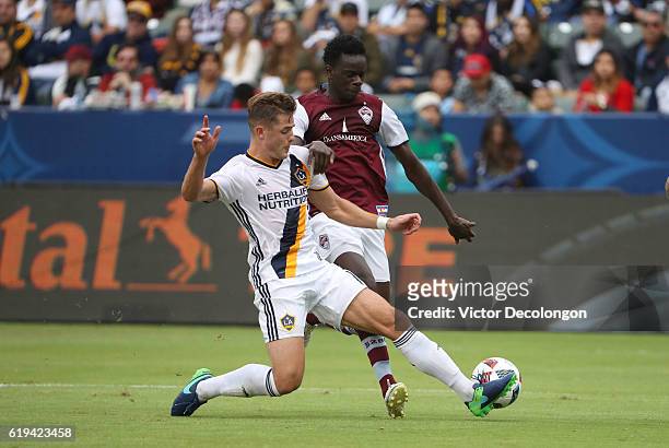 Robbie Rogers of the Los Angeles Galaxy plays the ball clear from Dominique Badji of the Colorado Rapids during the first half of leg one of the Audi...